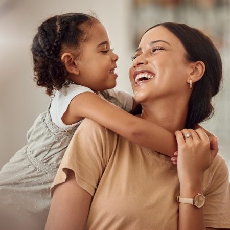 Happy mama with girl child, hug in home and weekend play time lifestyle for mom parent. Funny crazy kid in living room,  mother holding toddler with smile and love bonding together on mothers day.