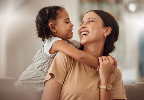 Happy mama with girl child, hug in home and weekend play time lifestyle for mom parent. Funny crazy kid in living room,  mother holding toddler with smile and love bonding together on mothers day.