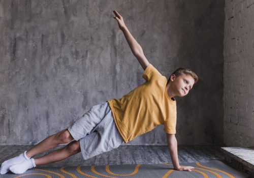 close-up-boy-doing-stretching-exercising-against-concrete-wall