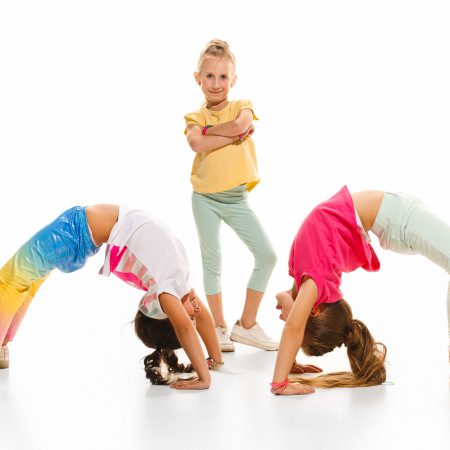 The kids dance school, ballet, hiphop, street, funky and modern dancers on white studio background. Girl is showing aerobic and dance element. Teen in hip hop style