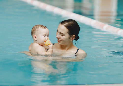 Little cute baby boy. Mother with son. Family playing in a water.