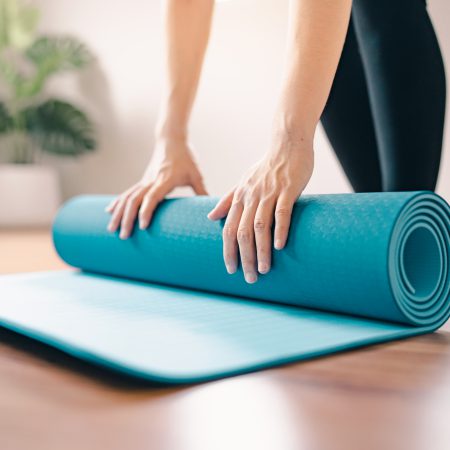 woman-roll-out-yoga-mat-preparation